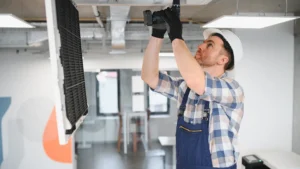 Hvac technician installing air conditioning unit in office building